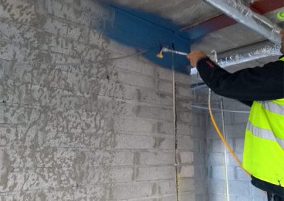 Air Tightness Testing & Thermal Imaging Dublin SOLUTION - Applying air tightness paint to seal pouris concrete blocks before installing metal ceiling